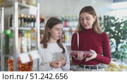 Teenage girl and her mother choosing beef entrecote in grocery. Стоковое видео, видеограф Яков Филимонов / Фотобанк Лори