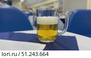 Experience the Charming Beer Scene in a Cozy and Inviting Dining Car with Friends and Good Company. A refreshing and cold beer sits atop a table in a cozy and comfortable dining car setting, evoking pure relaxation. Стоковое видео, видеограф worker / Фотобанк Лори