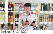 Adult man choosing beer in grocery store. Стоковое видео, видеограф Яков Филимонов / Фотобанк Лори