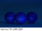 Three glitter christmas balls on dark blue background. Copy space, selective focus. Стоковое фото, фотограф Зарифа Арсланова / Фотобанк Лори