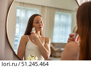 Middle-aged Woman Engages in Skin Care Routine With Electrical Device Indoors. Стоковое фото, фотограф Aleksandr Golubev / Фотобанк Лори