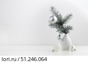 Fir branch and Christmas decorations in a vase on a white table. Стоковое фото, фотограф Ирина Толокновская / Фотобанк Лори
