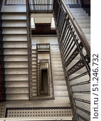 Vertical view of stairwell with metal railings and tiled floor patterns. Стоковое фото, фотограф Антон Гвоздиков / Фотобанк Лори