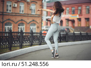 portrait of a girl in jeans and a t-shirt on the background of the building in the evening on a summer day. street dancing in the city. Стоковое фото, фотограф Арзюков Вадим Николаевич / Фотобанк Лори