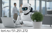 Futuristic humanoid robot with glowing blue eyes is working on a laptop in a modern office environment, showcasing advanced technology and innovation in the workplace. Стоковое AI-видео, аниматор Ирина Ручушкина / Фотобанк Лори