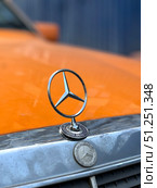 A Mercedes emblem is on the hood of an orange car. Russia. Moscow. 05.09.25. Редакционное фото, фотограф Ярославский Максим / Фотобанк Лори