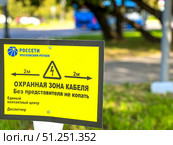 A yellow sign with Russian writing on it warns of a 2 meter power line. Russia. Moscow. 05.09.25. Редакционное фото, фотограф Ярославский Максим / Фотобанк Лори