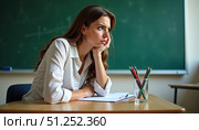Разгневанный учитель сидит за столом. An angry teacher is sitting at the table. Стоковое AI-изображение, AI-художник ketpro.design / Фотобанк Лори