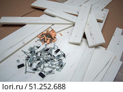 Furniture fasteners are poured out in a pile on furniture parts. Стоковое фото, фотограф Екатерина Кузнецова / Фотобанк Лори