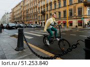 Девушка на складном велосипеде едет по улице исторического центра города. Редакционное фото, фотограф Кирилл Сиротюк / Фотобанк Лори