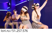Cheerful young female friends wearing VR headsets and holding controllers having fun in virtual reality studio, competing in two-on-two shooter game. Стоковое видео, видеограф Яков Филимонов / Фотобанк Лори