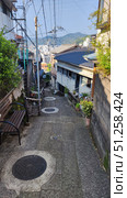 Nagasaki, Japan - May 12, 2025. Street goes down through the residential area. Стоковое фото, фотограф Константин Никитеев / Фотобанк Лори