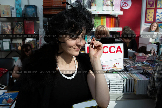 06.04.2023, Москва. Международная ярмарка интеллектуальной литературы «non/fictioNвесна» в Гостином дворе. Девушка с книгой на ярмарке. Редакционное фото, фотограф Дмитрий Киселёв / Фотобанк Лори