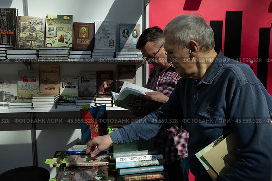 06.04.2023, Москва. Международная ярмарка интеллектуальной литературы «non/fictioNвесна» в Гостином дворе. Мужчины смотрят книги на прилавке. Редакционное фото, фотограф Дмитрий Киселёв / Фотобанк Лори