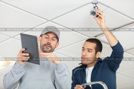 2 professionals cctv technicians working. Стоковое фото, агентство Ingram Publishing / Фотобанк Лори