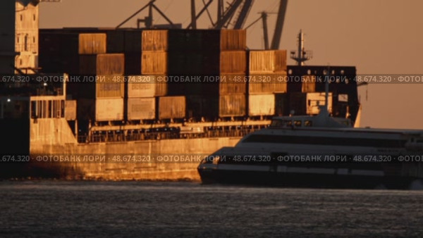 21 may 2025, Lisbon. Portugal - Ferry passing by a large container ship at sunset. Редакционное видео, видеограф Константин Шишкин / Фотобанк Лори