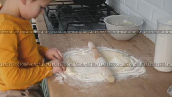 6 years old boy cooking pizza in the kitchen. Child rolling up the dough, adding cheese, tomatoes and smear sauce the base. Preschool kid making homemade pizza. Cooking class, culinary. Little baker. Стоковое видео, видеограф Марина Демидюк / Фотобанк Лори