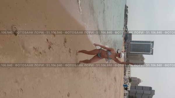 A 50-year-old European woman in a swimsuit walks along the beach in Doha, Qatar. Стоковое видео, видеограф IRYNA ZAKHARANKA / Фотобанк Лори