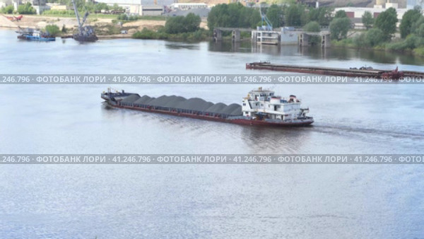 A barge transports cargo on the river in the summer. Transportation of wooden logs on the river. Летом баржа перевозит грузы по реке. Перевозка деревянных бревен по реке. Стоковое видео, видеограф Egor Sarantstv / Фотобанк Лори