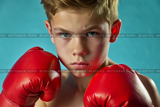 A boy in boxing gloves strikes, a cute teenage boy stands in a fighter's pose, ready to fight. Playing sports. Children's sports sections. Стоковое AI-изображение, AI-художник Photojuli / Фотобанк Лори