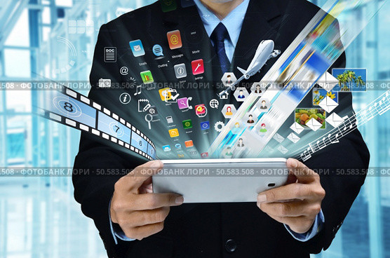 A businessman accesing internet and information technology via tablet / gadget in his hand. Стоковое фото, агентство Ingram Publishing / Фотобанк Лори