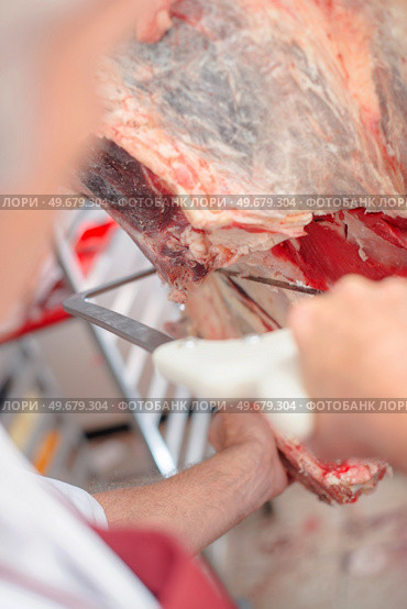 a butcher is calving beef. Стоковое фото, агентство Ingram Publishing / Фотобанк Лори