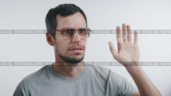 A cheerful man waves, his smile fading as an unexpected sight triggers confusion. Стоковое видео, видеограф Илья Шаматура / Фотобанк Лори