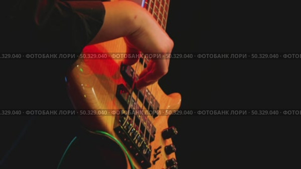 A close-up of his right hand skillfully fingering the strings of a bass guitar. Work of a professional musician in a recording studio. Стоковое видео, видеограф Воловодов Владимир / Фотобанк Лори
