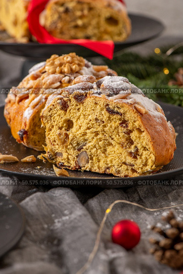 A close-up view of a slice of Bolo Rainha reveals its moist texture, studded with nuts and dried fruit, and dusted with powdered sugar. A festive treat. Стоковое фото, агентство Ingram Publishing / Фотобанк Лори