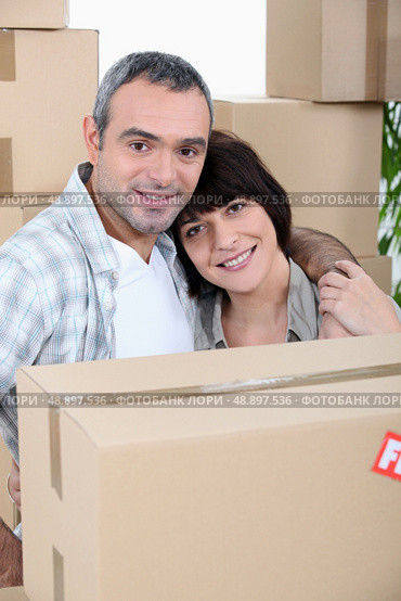 a couple in front of a pile of cartons. Стоковое фото, агентство Ingram Publishing / Фотобанк Лори