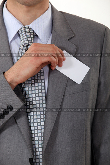 A cropped picture of a businessman putting his card in his pocket. Стоковое фото, агентство Ingram Publishing / Фотобанк Лори