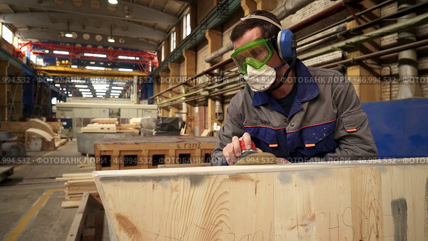 A dedicated craftsman is diligently working on a piece of wood in his specialized workshop. Стоковое фото, фотограф David Kashakhi / Фотобанк Лори