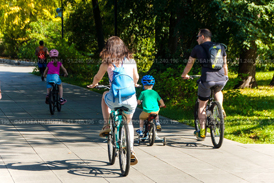A family of four is riding bikes together on a path.  Russia. Moscow. 24.08.25. Редакционное фото, фотограф Ярославский Максим / Фотобанк Лори