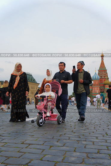 A family of visitors from Central Asia walks with a child on Red Square in the evening. Russia. Moscow. 21.07.25. Редакционное фото, фотограф Ярославский Максим / Фотобанк Лори