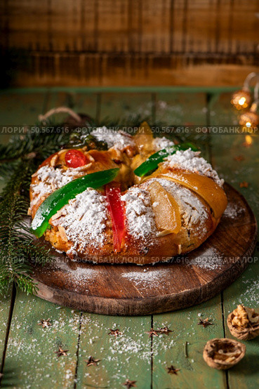 A festive King Cake adorned with colorful candied fruits, dusted with powdered sugar, and ready to be shared. Стоковое фото, агентство Ingram Publishing / Фотобанк Лори