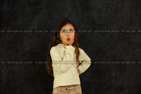 A Five-Year-Old Girl Stands Confidently With Her Hand on Her Chin, Pondering Something Intriguing. Стоковое фото, фотограф Aleksandr Golubev / Фотобанк Лори