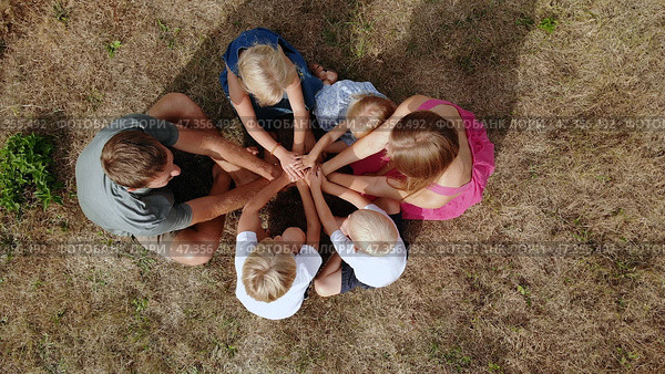 A friendly family joins hands together as a sign of the unity and strength of the family. Drone view. Стоковое фото, фотограф Mikhail Davidovich / Фотобанк Лори