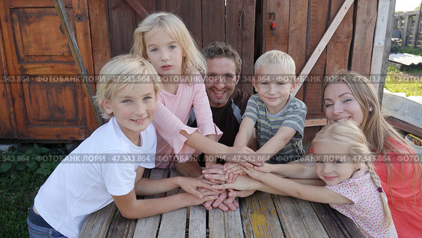 A friendly family joins their hands as a sign of joint success. Стоковое фото, фотограф Mikhail Davidovich / Фотобанк Лори