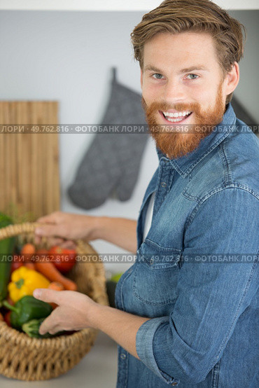 a friendly man with a huge basket of vegetables. Стоковое фото, агентство Ingram Publishing / Фотобанк Лори