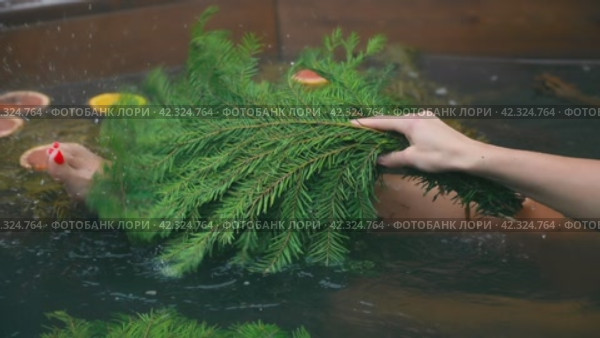 A girl in a bath pot rubs her leg with a broom on video. Стоковое видео, видеограф Юрий Поздников / Фотобанк Лори