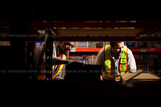 A group of warehouse employees, Inspecting products on warehouse shelves before they are sent to retailer. Стоковое фото, агентство Ingram Publishing / Фотобанк Лори