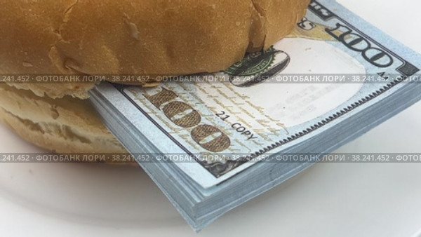 A hamburger with a wad of dollars is spinning on a white plate. Food and money. Стоковое видео, видеограф Ярославский Максим / Фотобанк Лори