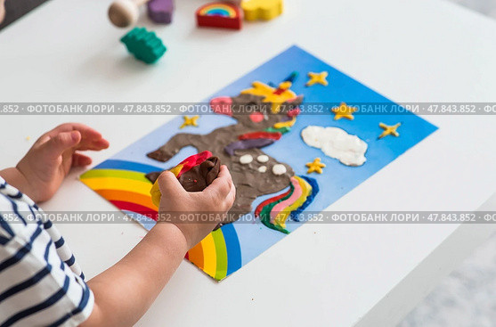 A little boy is playing with plasticine. Fine motor skills-developing games for children. The kid makes a horse. Useful games for child development. Стоковое фото, фотограф Photojuli / Фотобанк Лори