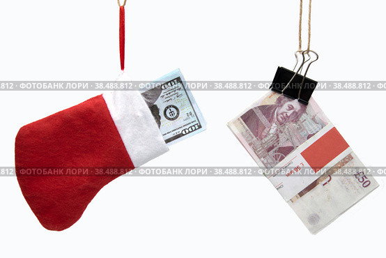 A lot of dollars in a Christmas sock and a bundle of pounds on a white background. Стоковое фото, фотограф Ярославский Максим / Фотобанк Лори