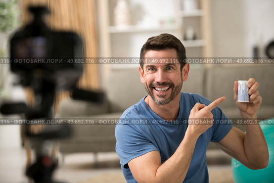 a male sport blogger recording video at home. Стоковое фото, агентство Ingram Publishing / Фотобанк Лори