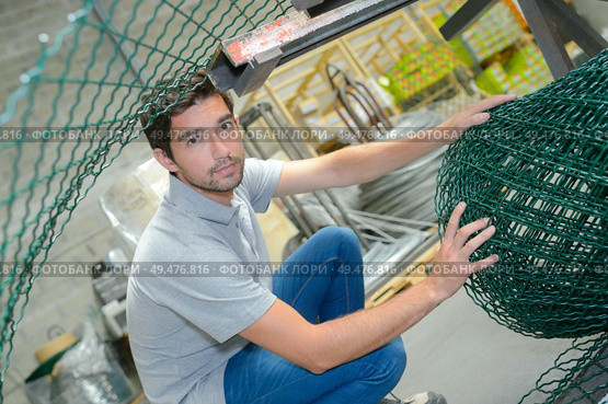 a male worker with fencing roll. Стоковое фото, агентство Ingram Publishing / Фотобанк Лори