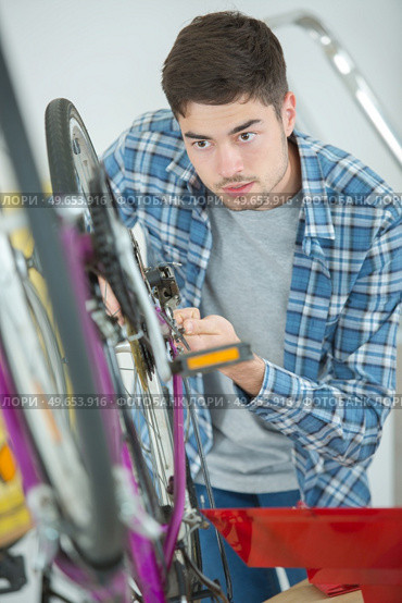 a man changing the bikes breaks. Стоковое фото, агентство Ingram Publishing / Фотобанк Лори