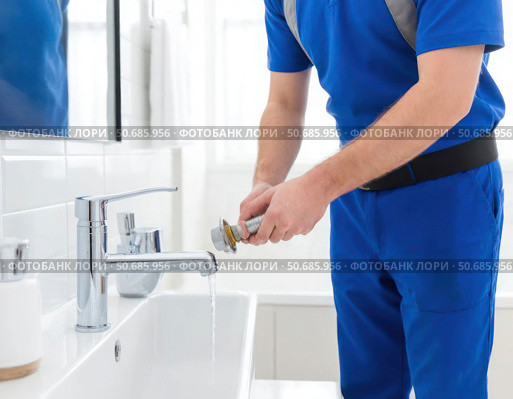 A man in a blue shirt is washing his hands at a sink. Стоковое AI-изображение, AI-художник Ярославский Максим / Фотобанк Лори