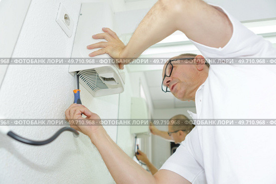 a man installing hand dryer. Стоковое фото, агентство Ingram Publishing / Фотобанк Лори