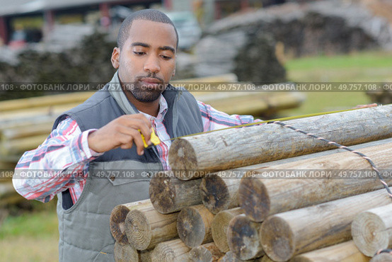 a man is measuring posts. Стоковое фото, агентство Ingram Publishing / Фотобанк Лори
